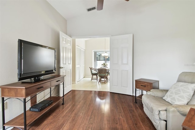 living room featuring lofted ceiling, ceiling fan with notable chandelier, and hardwood / wood-style flooring