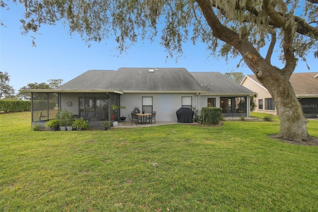 rear view of property featuring a patio area, a sunroom, and a yard