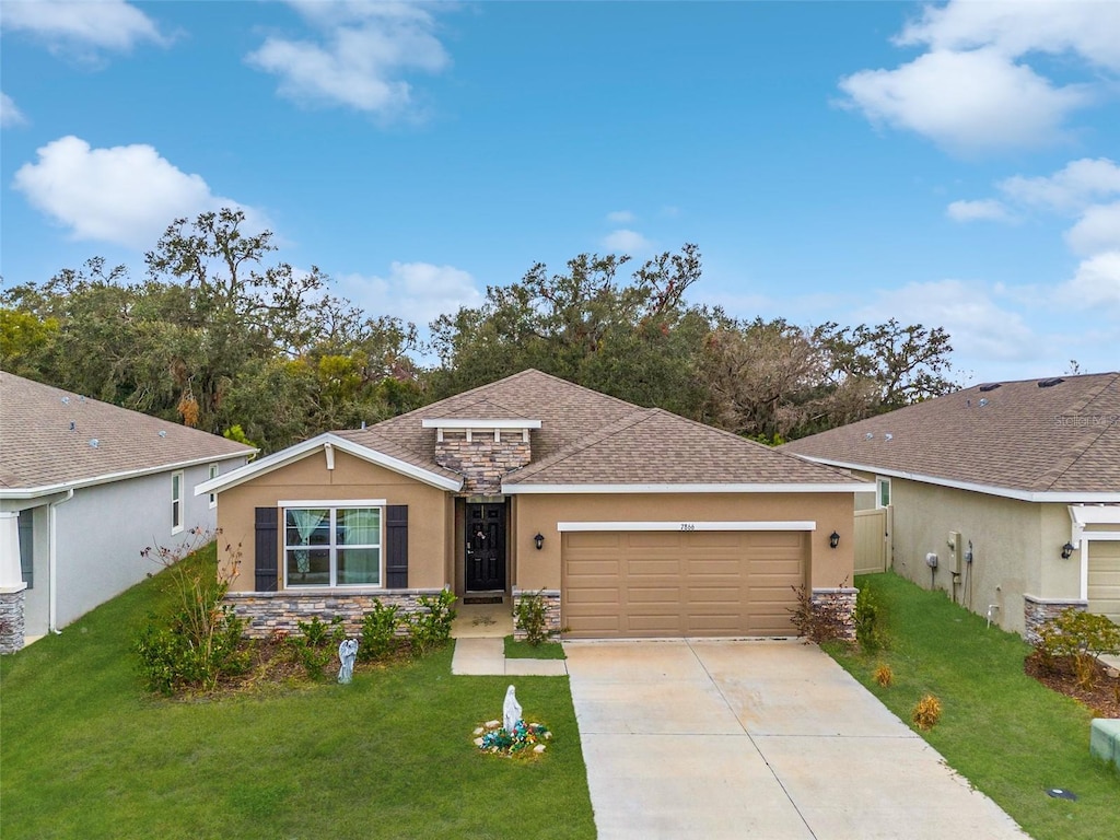 ranch-style home featuring a front lawn and a garage