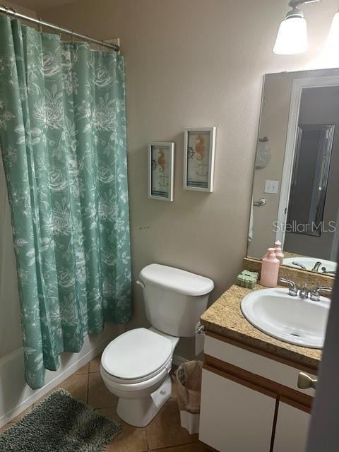 full bathroom with toilet, vanity, tile patterned flooring, and shower / tub combo with curtain