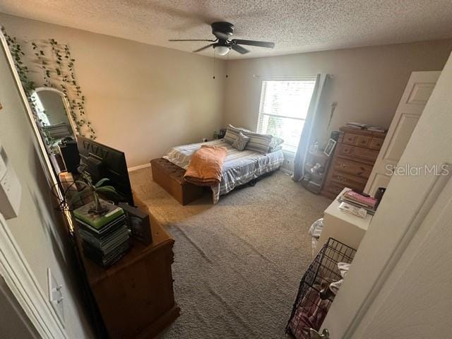 carpeted bedroom featuring ceiling fan and a textured ceiling