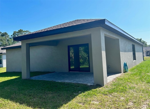 back of house featuring a patio area and a lawn