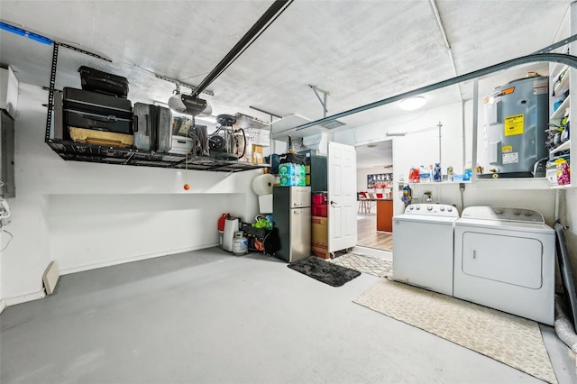 garage with water heater, a garage door opener, and separate washer and dryer