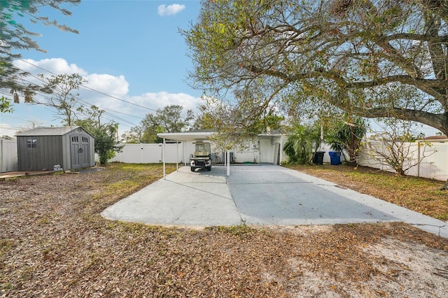 back of house with a carport and a shed