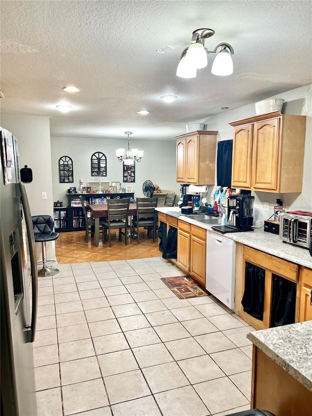 kitchen with dishwasher, light tile patterned flooring, stainless steel fridge, and a textured ceiling