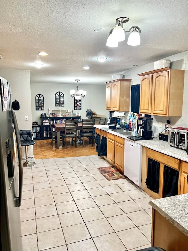 kitchen with stainless steel fridge with ice dispenser, dishwasher, light tile patterned floors, and a chandelier