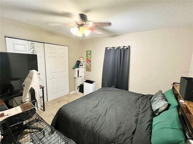 bedroom featuring light colored carpet, a closet, a textured ceiling, and a ceiling fan