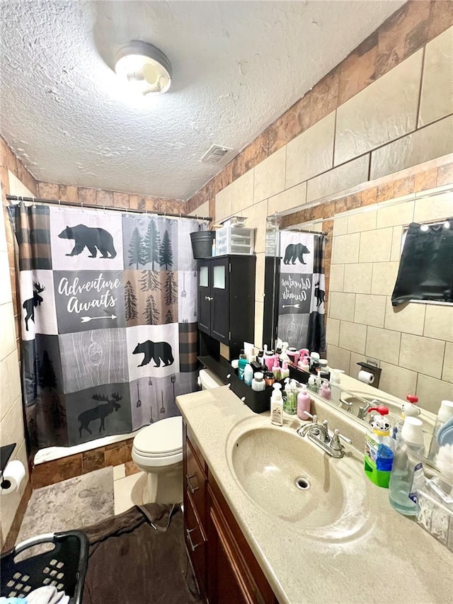 full bathroom featuring tile walls, a textured ceiling, and a shower with curtain