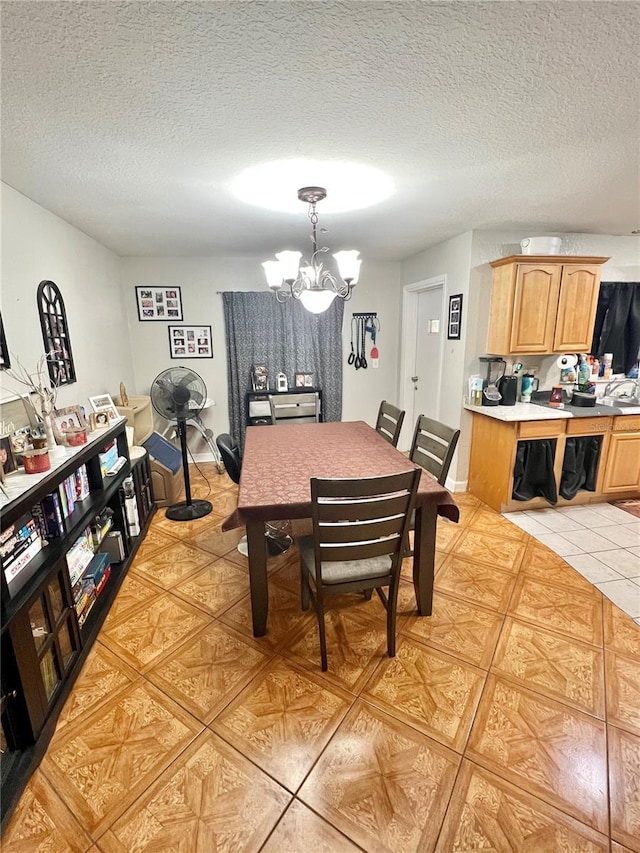 dining space with light tile patterned floors, a notable chandelier, and a textured ceiling