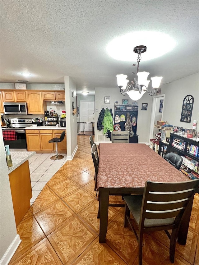 dining room featuring light tile patterned floors, baseboards, a chandelier, and a textured ceiling