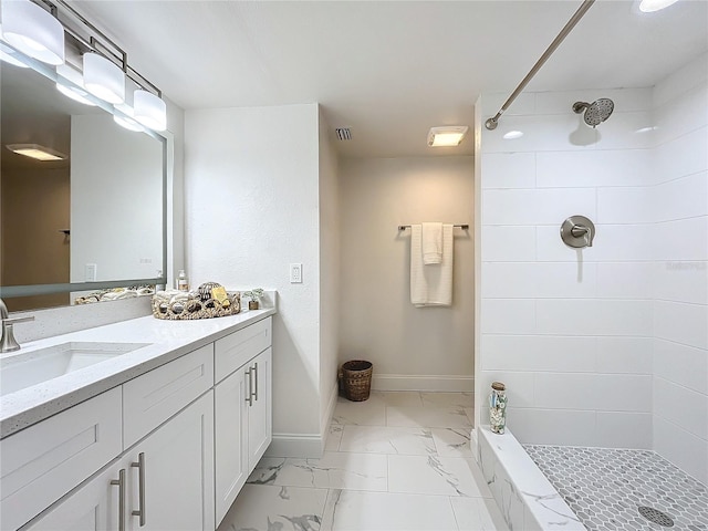 bathroom with a sink, visible vents, baseboards, marble finish floor, and a tile shower