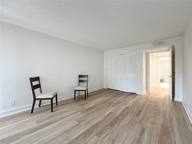 unfurnished room featuring light wood-style flooring, visible vents, and baseboards