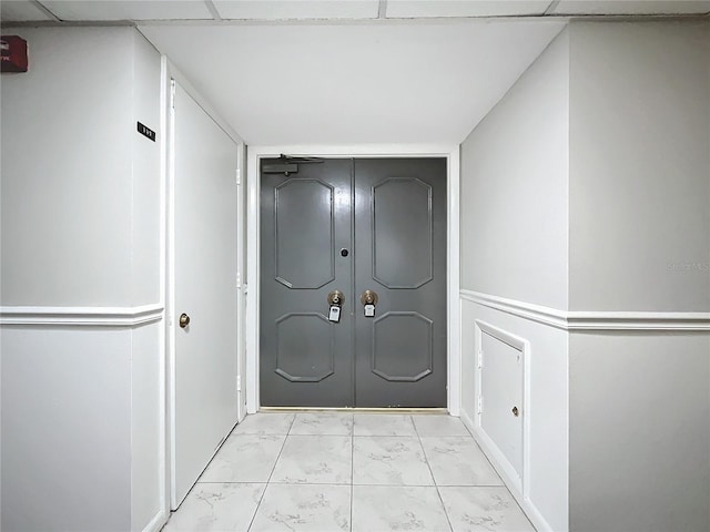 hallway featuring marble finish floor