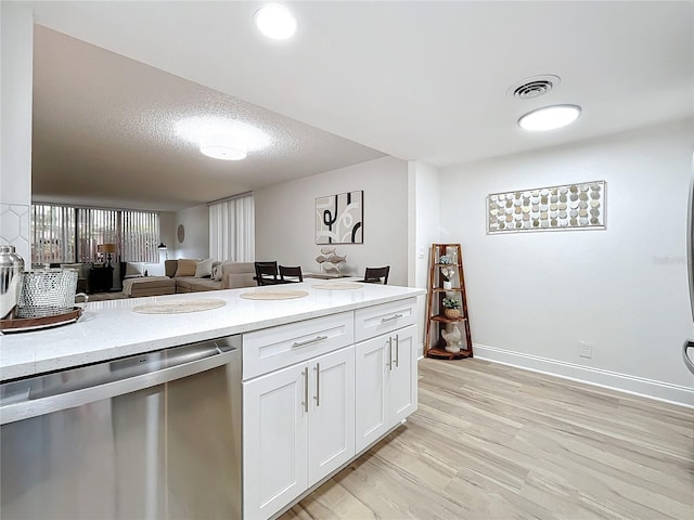 kitchen featuring visible vents, white cabinets, open floor plan, light wood-type flooring, and dishwasher