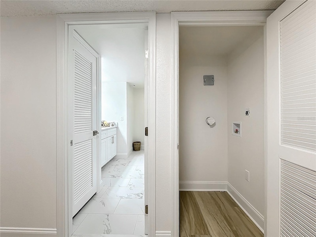 hallway with marble finish floor and baseboards