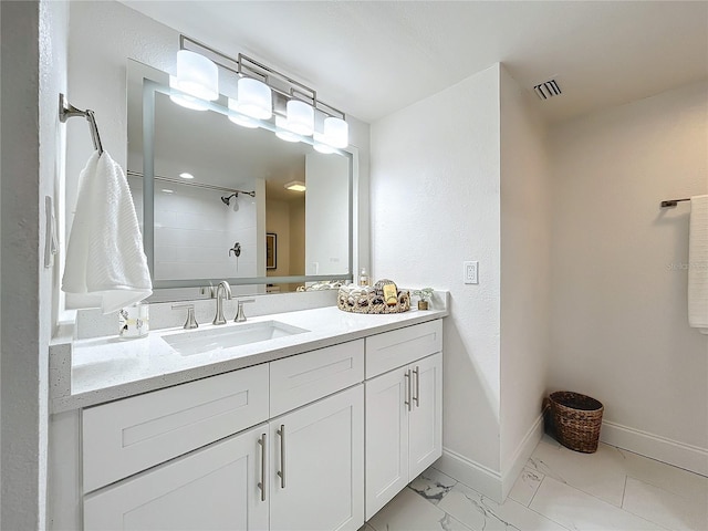 bathroom with baseboards, visible vents, marble finish floor, a tile shower, and vanity