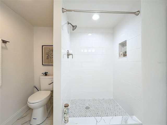 bathroom with marble finish floor, baseboards, a tile shower, and toilet