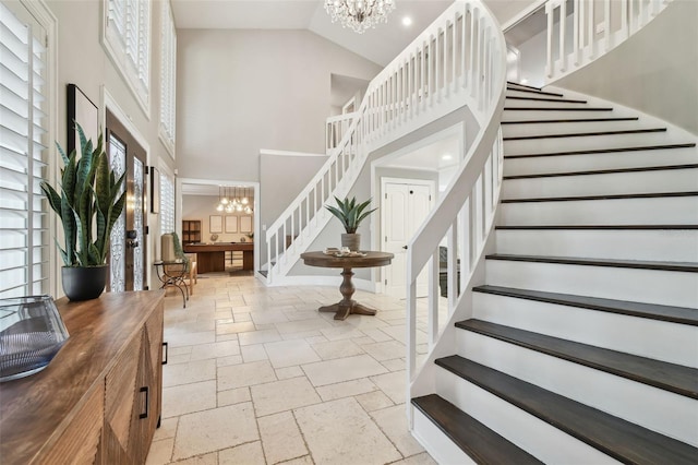 foyer featuring high vaulted ceiling, a wealth of natural light, and an inviting chandelier