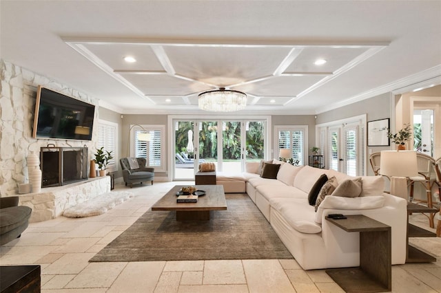 living room with french doors, a stone fireplace, a notable chandelier, ornamental molding, and coffered ceiling