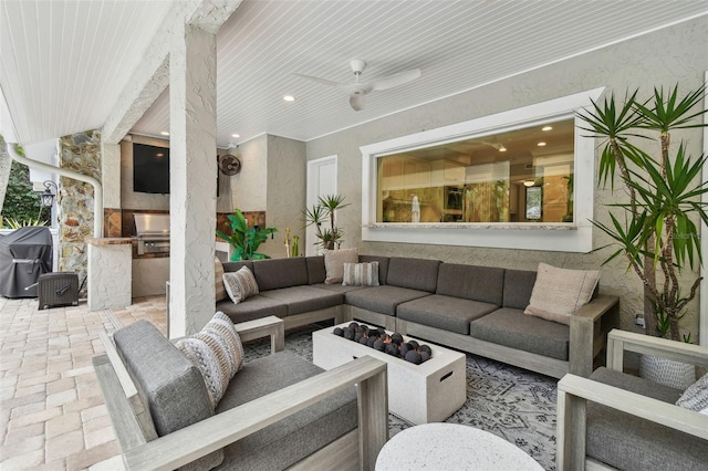 view of patio featuring area for grilling, grilling area, ceiling fan, and an outdoor living space with a fire pit