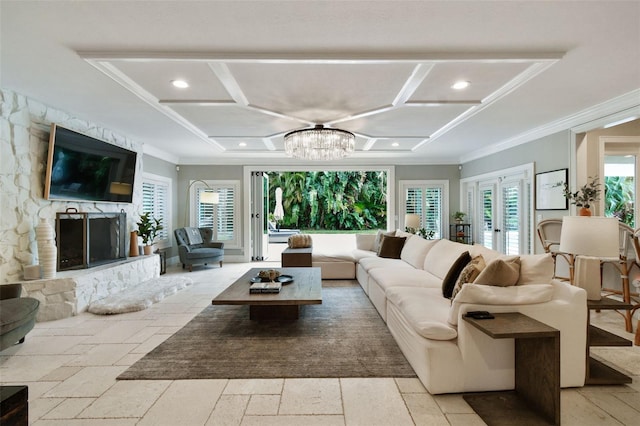 living room featuring a notable chandelier, coffered ceiling, ornamental molding, and a fireplace