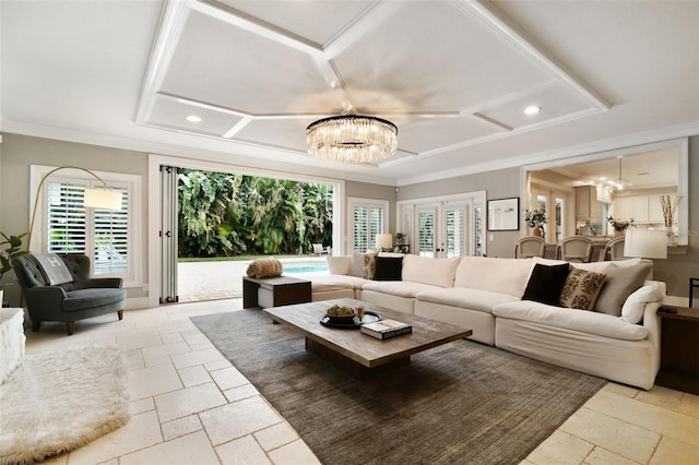 living room with a raised ceiling, a notable chandelier, and a healthy amount of sunlight