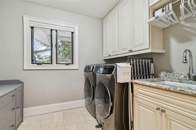 washroom featuring sink, cabinets, and washing machine and clothes dryer