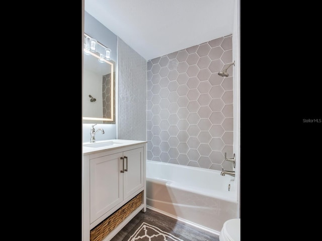 full bathroom featuring tiled shower / bath combo, vanity, wood-type flooring, and toilet