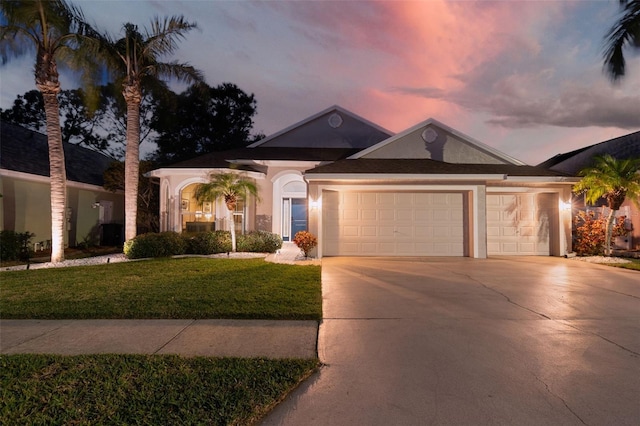 ranch-style house with a garage and a yard