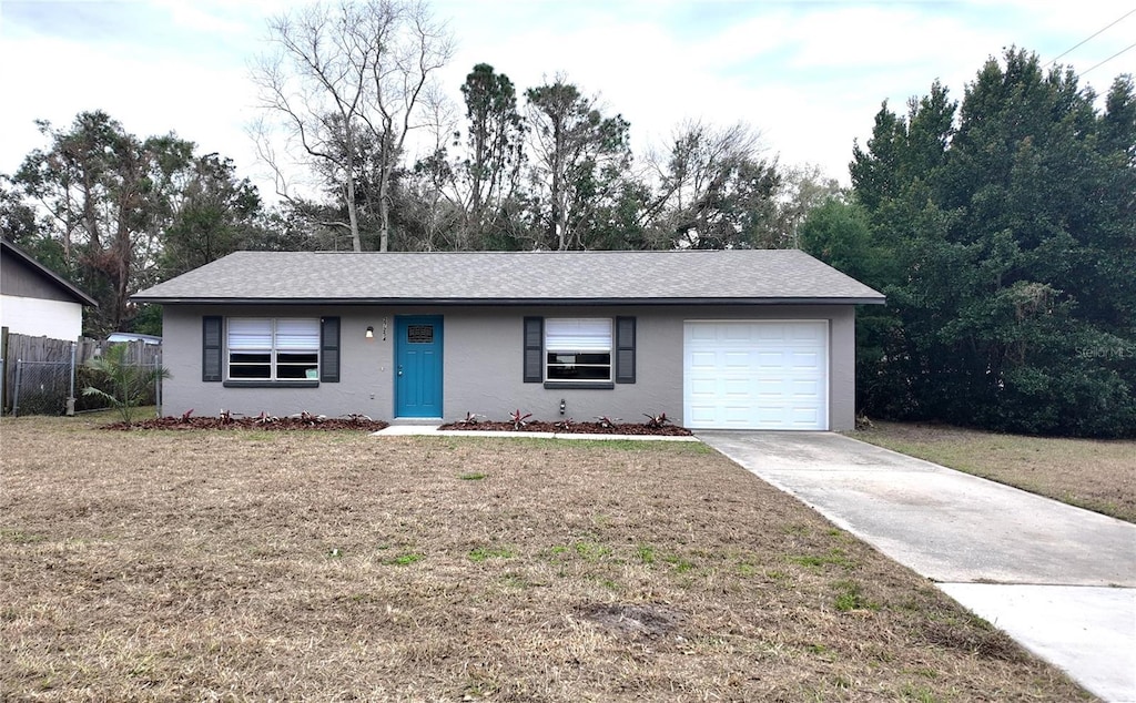 single story home with a garage and a front yard