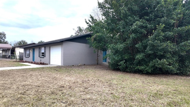 view of side of home featuring a garage and a lawn