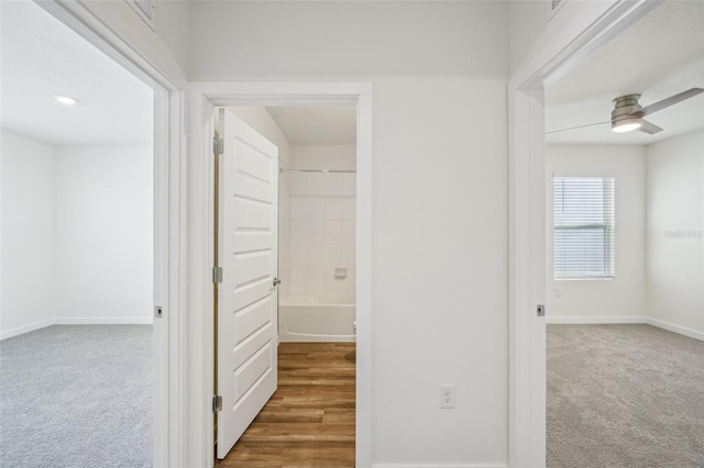 hall featuring dark colored carpet