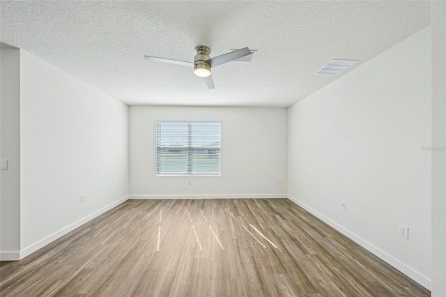 spare room with ceiling fan, a textured ceiling, and hardwood / wood-style flooring