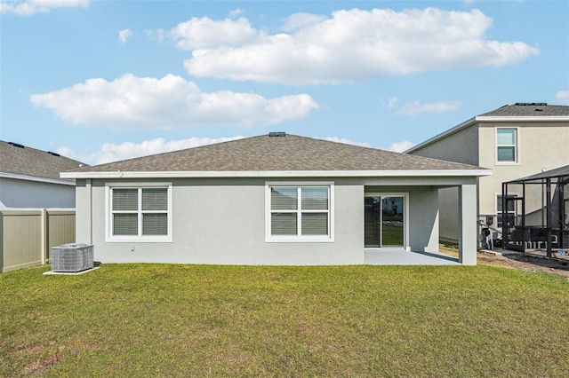 rear view of property featuring a patio area, central AC unit, and a lawn