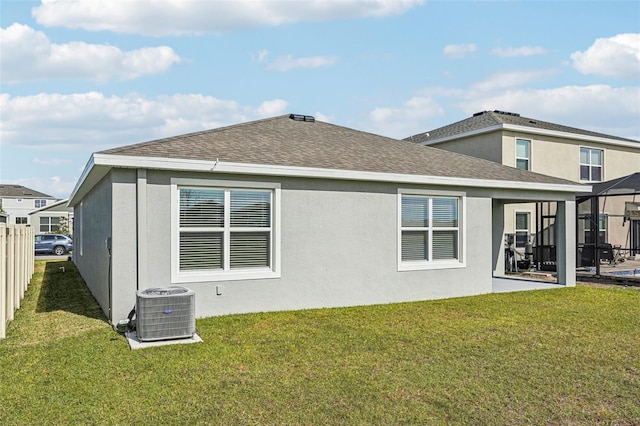 back of property featuring a lawn and central air condition unit