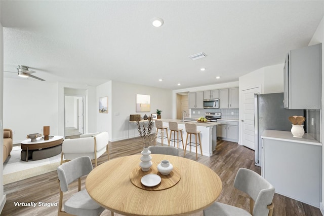 dining space featuring sink, ceiling fan, dark hardwood / wood-style floors, and a textured ceiling