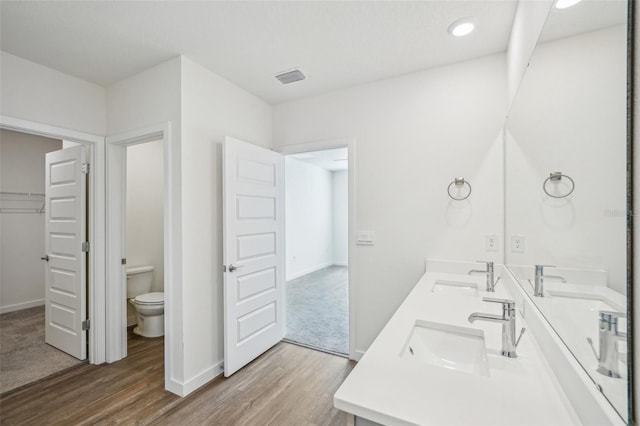31814 Oyster Trellis Ln, Wesley Chapel, FL 33545 - full bathroom featuring wood finished floors, toilet, baseboards, double vanity, and recessed lighting