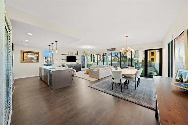 dining room featuring a notable chandelier, sink, and dark hardwood / wood-style flooring