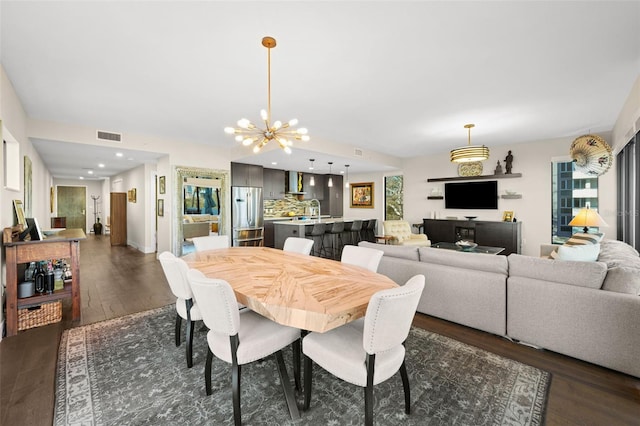 dining space with sink, a notable chandelier, and dark hardwood / wood-style flooring