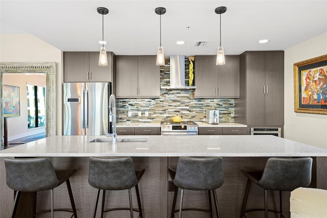 kitchen with a breakfast bar, decorative backsplash, wall chimney exhaust hood, and stainless steel appliances