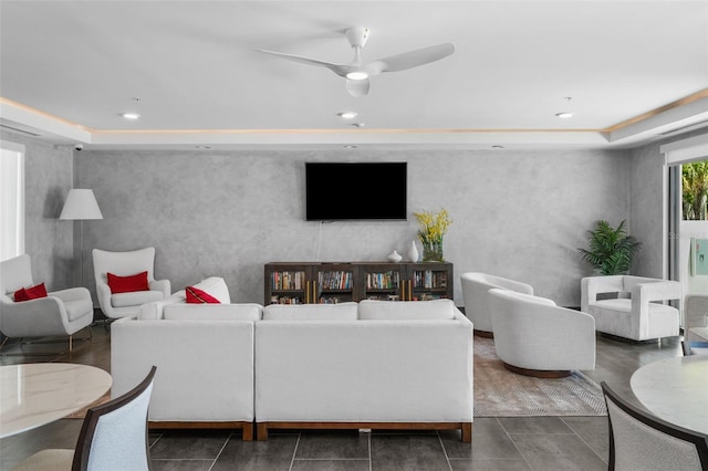 living room with ceiling fan and a tray ceiling