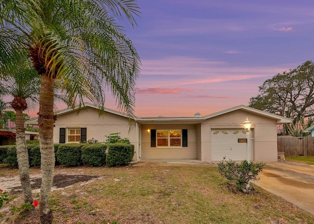 ranch-style home with a garage and a yard