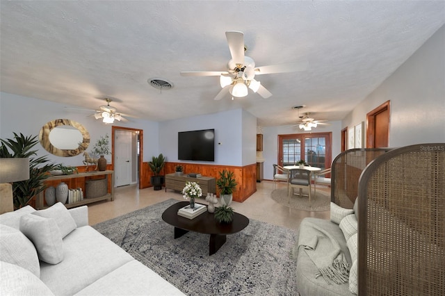 living room with a textured ceiling and ceiling fan