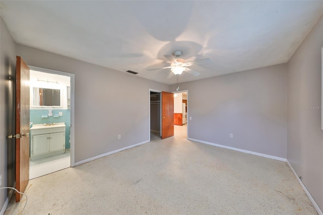 unfurnished bedroom featuring ceiling fan, a closet, and ensuite bathroom