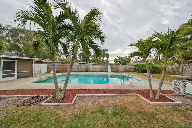 view of swimming pool featuring a sunroom, a yard, and a patio