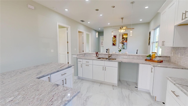 kitchen featuring ceiling fan, white cabinets, light stone countertops, and sink