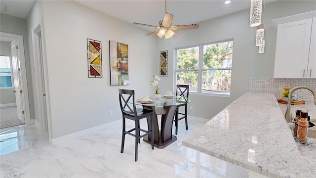 dining room featuring ceiling fan and sink