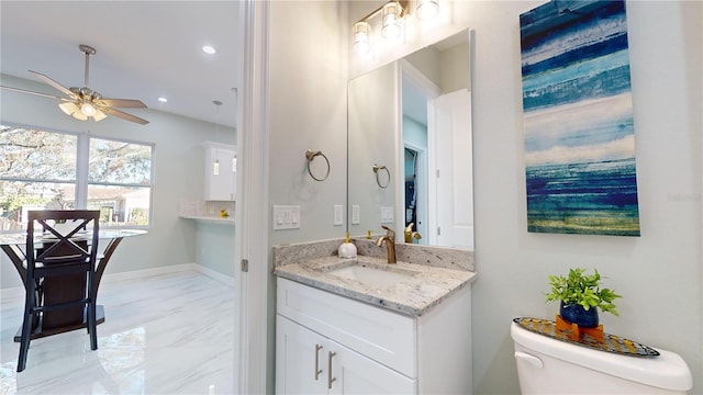 bathroom with tasteful backsplash, vanity, ceiling fan, and toilet