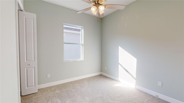 carpeted spare room featuring ceiling fan and lofted ceiling