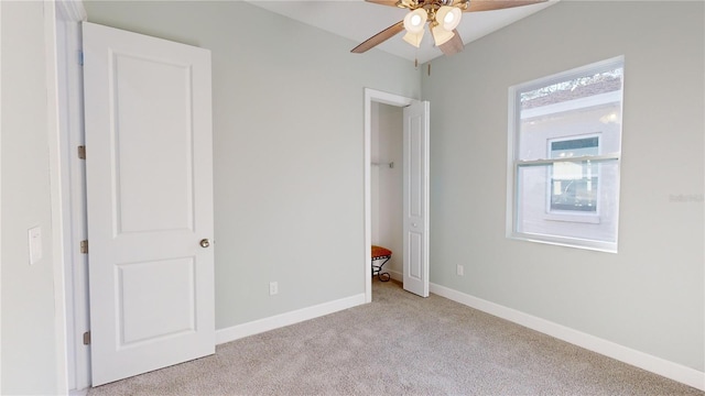 unfurnished bedroom featuring ceiling fan, light colored carpet, and multiple windows